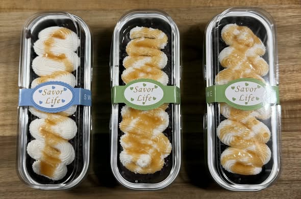 Three mini desserts with white piped topping and golden drizzle