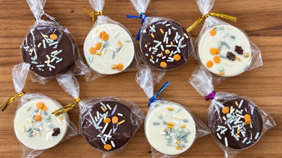 Individually wrapped dark and white chocolate-covered treats with colorful sprinkles